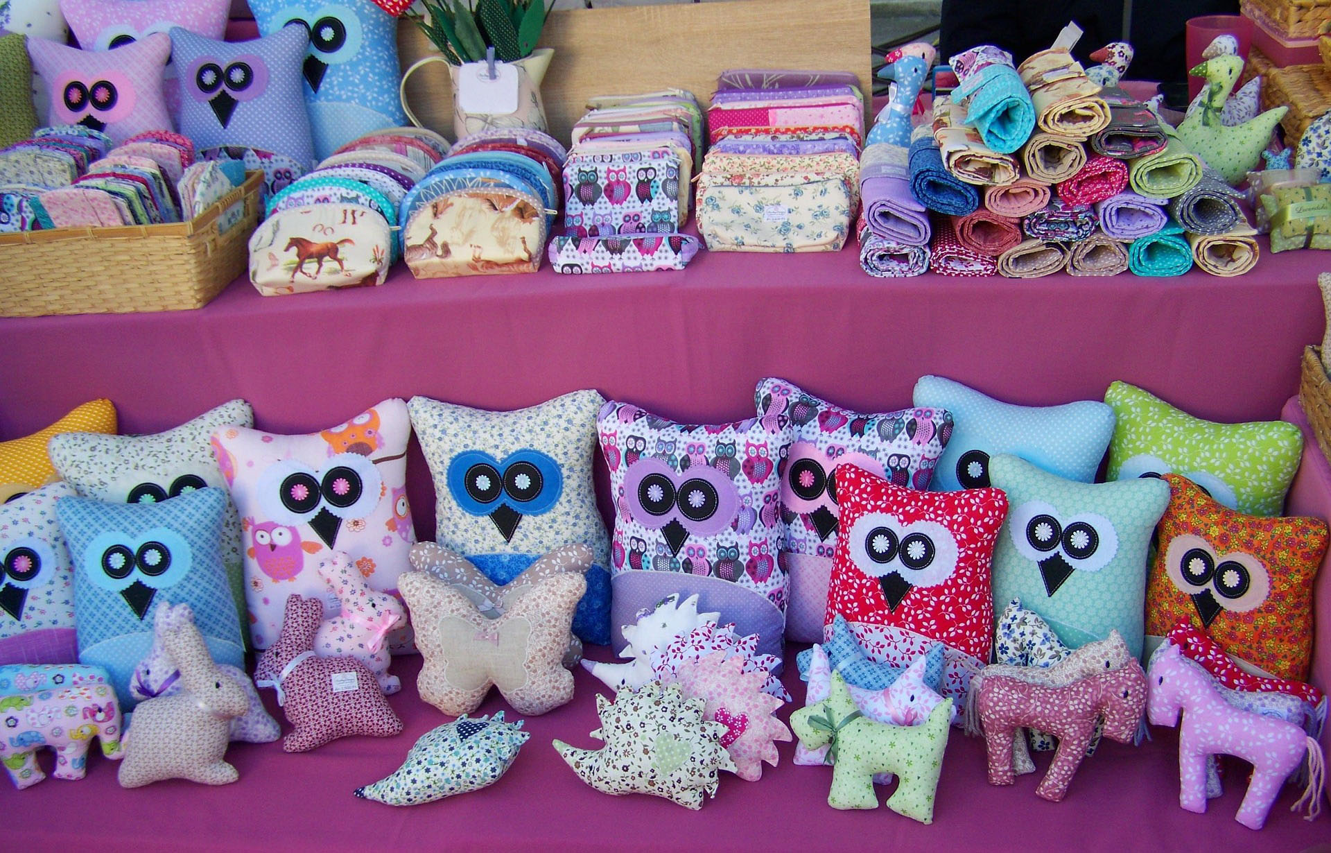 Craft fair displaying handmade cushions and purses at a UK craft and hobby fair
